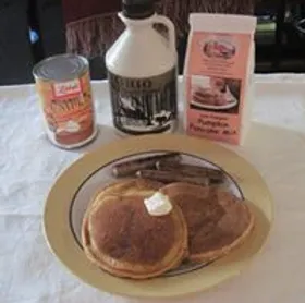 A plate with pancakes next to condiments.